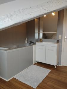 a white kitchen with a sink and a counter at Grand T2 climatisé très calme in Périgueux