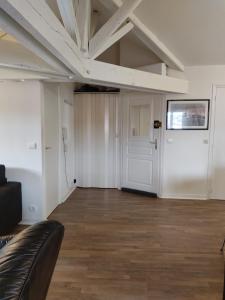 an empty room with a couch and a door at Grand T2 climatisé très calme in Périgueux