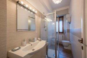 a bathroom with a sink and a toilet and a mirror at Entro le mura in Montepulciano +20 photos