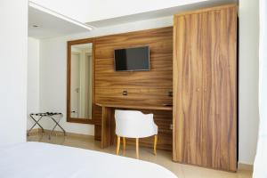 a bedroom with a tv on a wooden wall at Hotel El Djenina in Tangier