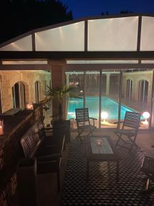 een patio met stoelen, een tafel en een zwembad bij Villa & Spa dans le Périgord in Proissans