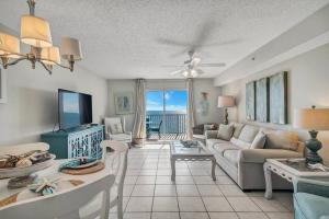 a living room with a couch and a table at Fourwinds 803 - Beachfront condo w/ Hall Bunks! - Elevator replacement 4/4-5/24 in Orange Beach