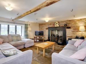 sala de estar con sofás y chimenea en The Birches, en Craswall