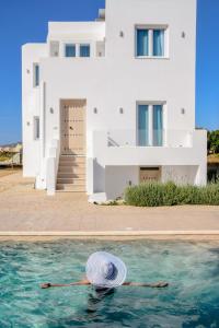 uma pessoa na água em frente a uma casa em Divine Naxos Villa em Plaka