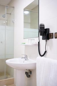 uma casa de banho com um lavatório e um telefone na parede em Hotel El Djenina em Tânger