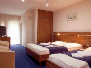 una camera d'albergo con due letti e una televisione di Penzion Fortune a Dunajská Streda