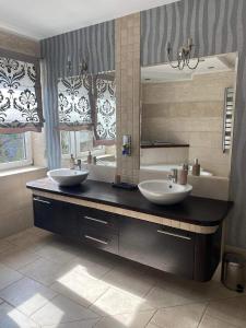 uma casa de banho com 2 lavatórios e um espelho grande em Apartament Ełk Centrum em Ełk