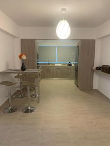 a kitchen with a table and stools in a room at KOS SUITE HOME in Platánion