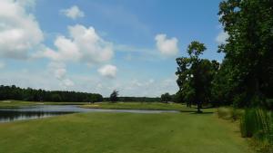 - une vue sur un parcours de golf avec un lac et des arbres dans l'établissement River Crossing #611 condo, à North Myrtle Beach