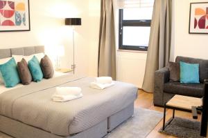 ein Schlafzimmer mit einem Bett mit Handtüchern darauf in der Unterkunft High Spec Luxury Studio Apartment in Sydenham in Sydenham