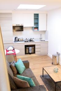 uma sala de estar com um sofá e uma cozinha em High Spec Luxury Studio Apartment in Sydenham em Sydenham