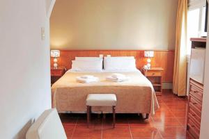 a bedroom with a bed with two towels on it at Hotel Ortegal in Mar del Plata