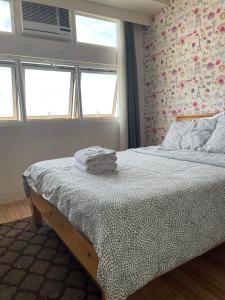 1 dormitorio con 1 cama en una habitación con ventanas en Cozy Studio Type Condo with Pool, en Biñan