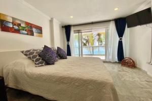 圣安德烈斯Apartamento en San Andrés Frente al Mar en Sun Rise的一间卧室，里面有一张床和一扇大窗户。