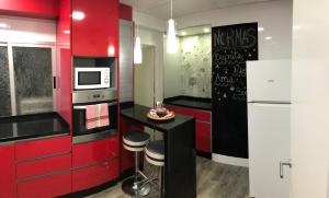 a kitchen with red cabinets and a white refrigerator at Atico3 - Ciudad de Berja in Berja