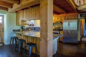 アシュランドにあるEuropean Style Straw Bale Retreatの冷蔵庫とスツールを備えた大きなカウンターのあるキッチン