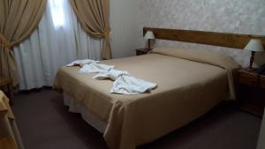 Una habitación de hotel con una cama con toallas. en Kalenshen Calafate en El Calafate