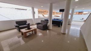 a living room with a pool table and two chairs at Magdalena Imperial Hotel in Girardot