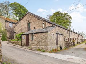 an old brick building on the side of a street at The Hayloft in Whaley Bridge