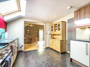a kitchen with wooden cabinets and a dining room at The Hayloft in Whaley Bridge