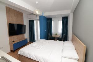 a bedroom with a white bed and a flat screen tv at NOCE Apartments - Premium Lake View in Ohrid +62 photos