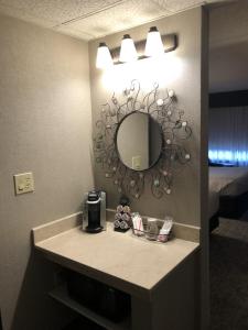 a bathroom with a sink with a mirror on the wall at The Academy Hotel Colorado Springs in Colorado Springs