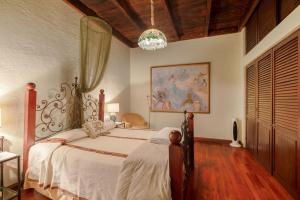a bedroom with a bed and a painting on the wall at Casa Los Jardínes in Antigua Guatemala