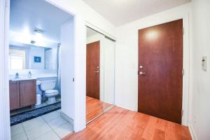 a bathroom with a toilet and a wooden door at PlanURstay - 310 Burnhamthorpe Road West in Mississauga