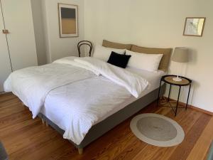 a bedroom with a bed with white sheets and pillows at charmant Leben im Textilviertel_zentral & ruhig in Augsburg