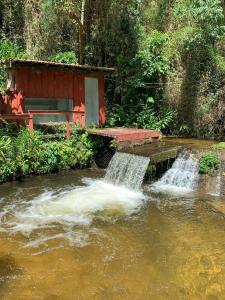 una panchina seduta accanto a una cascata accanto a un fiume di Chalet Teresopolis a Teresópolis