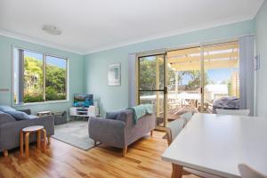 a living room with blue walls and a table and chairs at Beach Haven in Hawks Nest