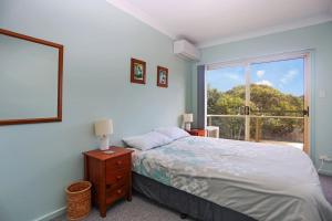 a bedroom with a bed and a large window at Beach Haven in Hawks Nest