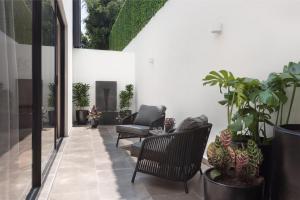 un patio con sillas y macetas en Leonora Luxury Plus by Viadora, en Ciudad de México