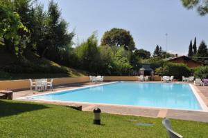 a large swimming pool with chairs in a yard at Lovely lake wiev&pool in Malcesine