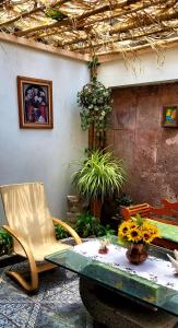 um quarto com uma mesa, uma cadeira e flores em Casa Q BnB em Cidade do México