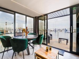 a dining room with a table and green chairs at Beautiful houseboat in Marina of Volendam with shared pool in Volendam