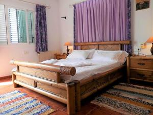a bedroom with a large bed with a wooden frame at Villa in Ibiza with Private Pool in Santa Eularia des Riu