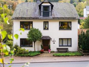 een wit huis met een bankje ervoor bij Spacious holiday home near Willingen with garden in Willingen