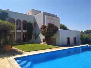 a villa with a swimming pool in front of a house at Villa in Ibiza with Private Pool in Santa Eularia des Riu