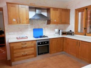 a kitchen with wooden cabinets and a stove top oven at Villa in Ibiza with Private Pool in Santa Eularia des Riu