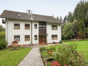 a white house with a garden in front of it at Cosy and spacious apartment with balcony in the Black Forest in Waldachtal