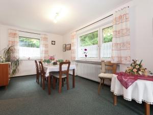 uma sala de jantar com mesa, cadeiras e janelas em Cosy and spacious apartment with balcony in the Black Forest em Waldachtal