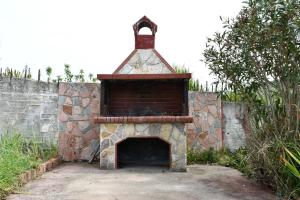 a stone fireplace with a brick wall next to at En Elladi Apartment in Alikanas