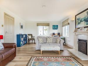 Una sala de estar con un sofá y una chimenea. en Penhallick House, en Tintagel