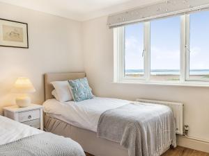 Un dormitorio con dos camas y una ventana. en Penhallick House, en Tintagel