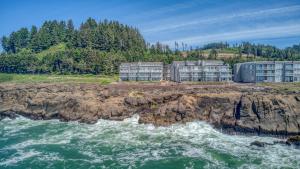 a group of buildings on a cliff next to the ocean at Whalers Rest in Depoe Bay