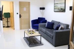 uma sala de estar com um sofá e uma mesa em Executive Bright and Airy Studio Apartment in Sydenham em Londres