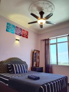 a bedroom with a bed with a ceiling fan at Glory beach resort private apartment in Port Dickson