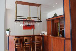 a kitchen with a bar with chairs around it at Wiking Hotel in Henstedt-Ulzburg