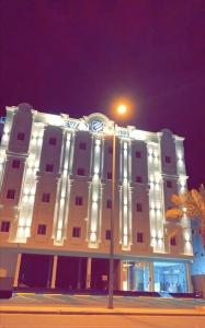 un bâtiment blanc avec un éclairage de rue devant lui dans l'établissement فندق ايوان, à Qal'at Bishah